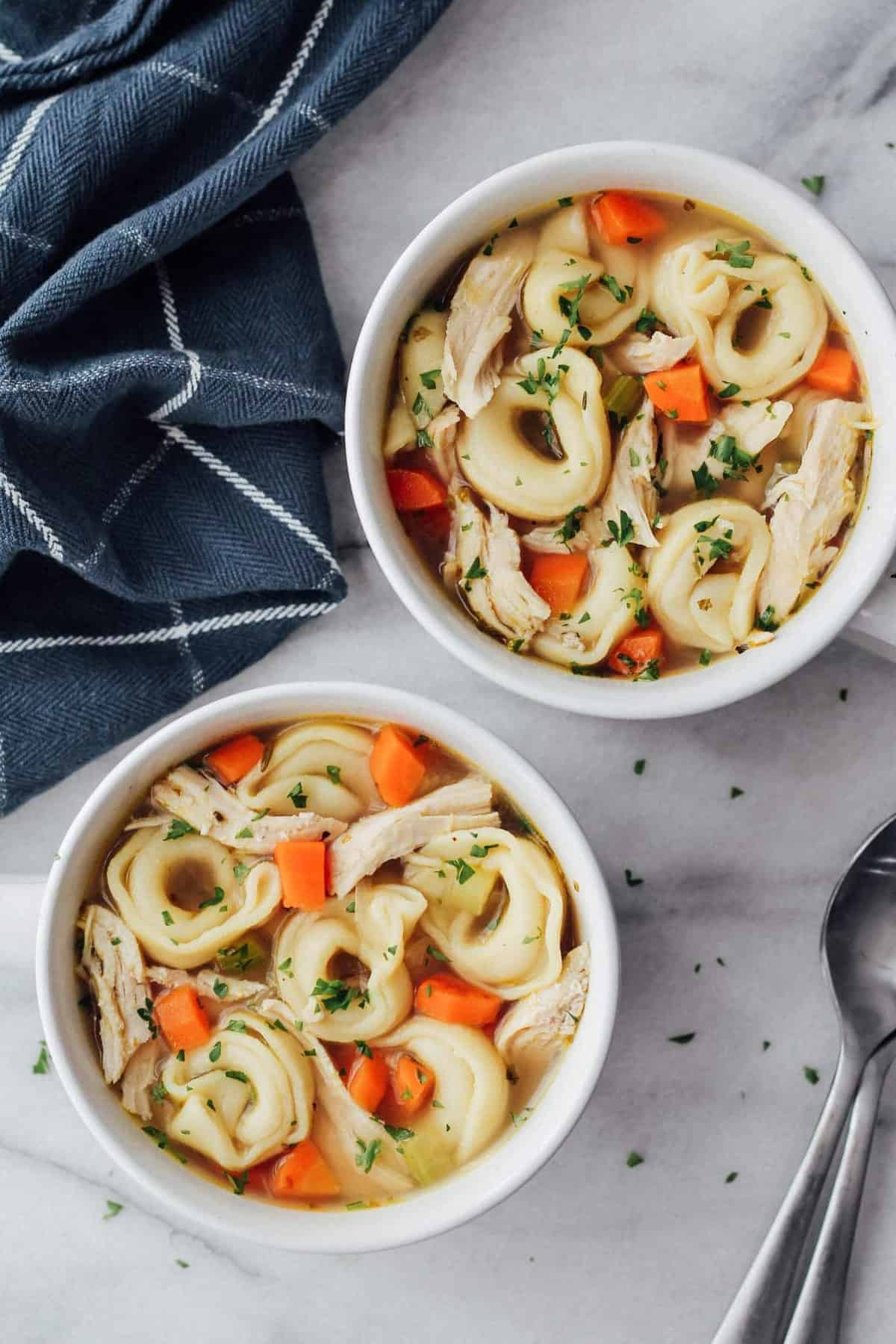 two bowls of chicken soup with tortellini