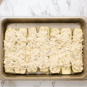 Uncooked zucchini boats are placed on a baking sheet.