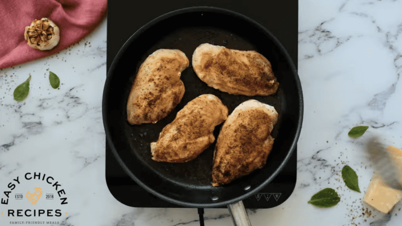 Chicken breasts are seared in a skillet.