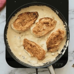 Chicken breasts are in a creamy sauce.