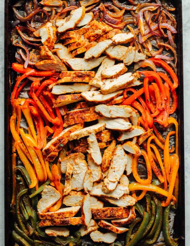 sheet pan chicken fajitas with sliced chicken and vegetables