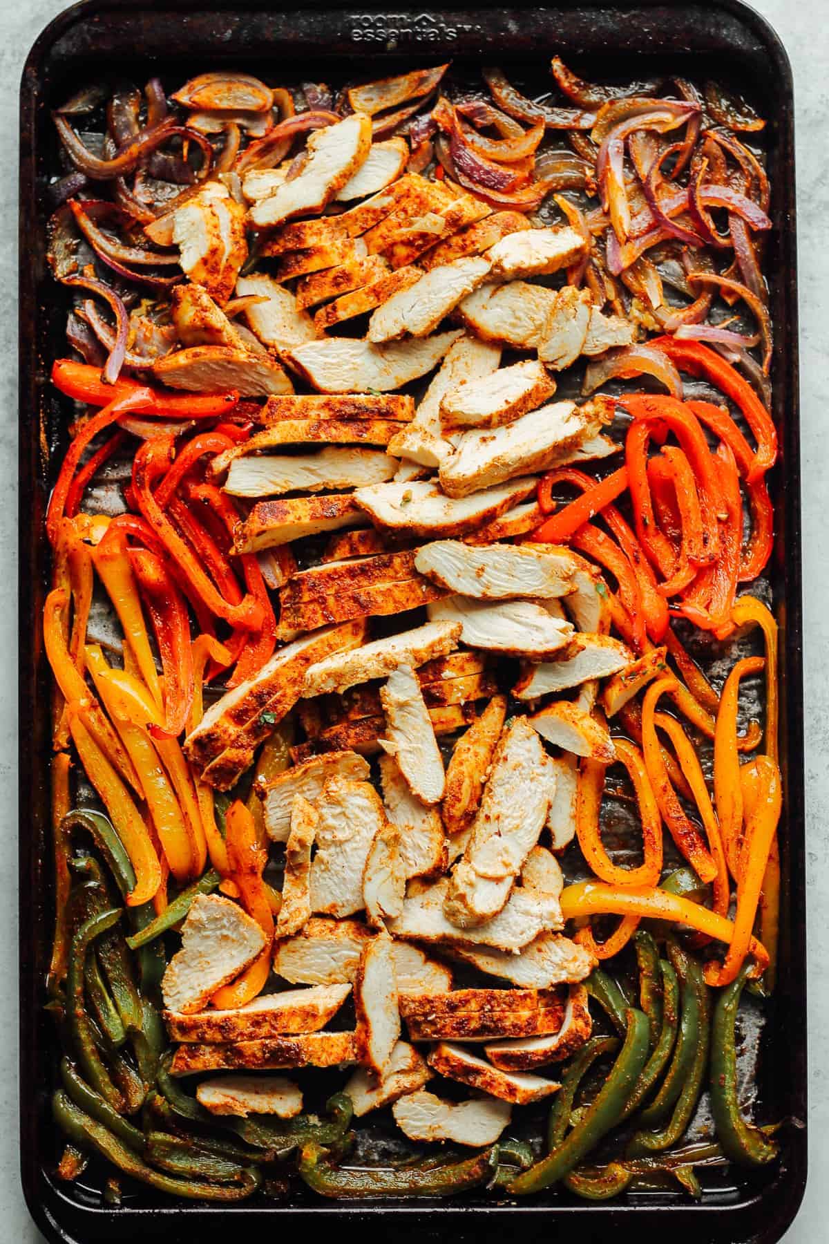 sheet pan chicken fajitas with sliced chicken and vegetables