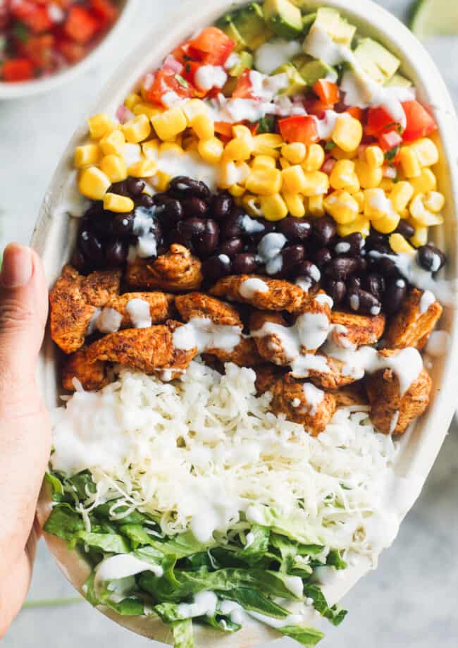 hand holding up copycat chipotle chicken burrito bowl