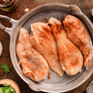 seasoned chicken breasts in a skillet.