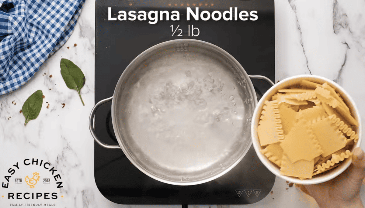 Lasagna noodles are being placed into a pot of boiling water. 