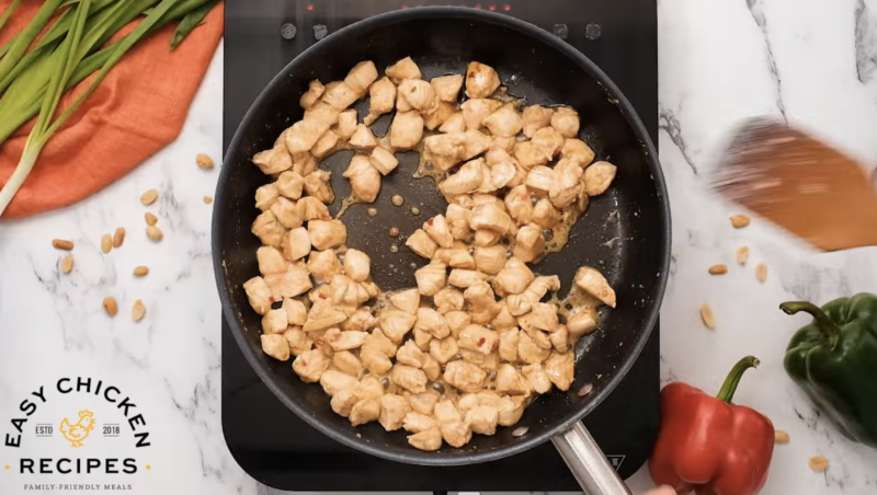 Chicken is cooking in a skillet.