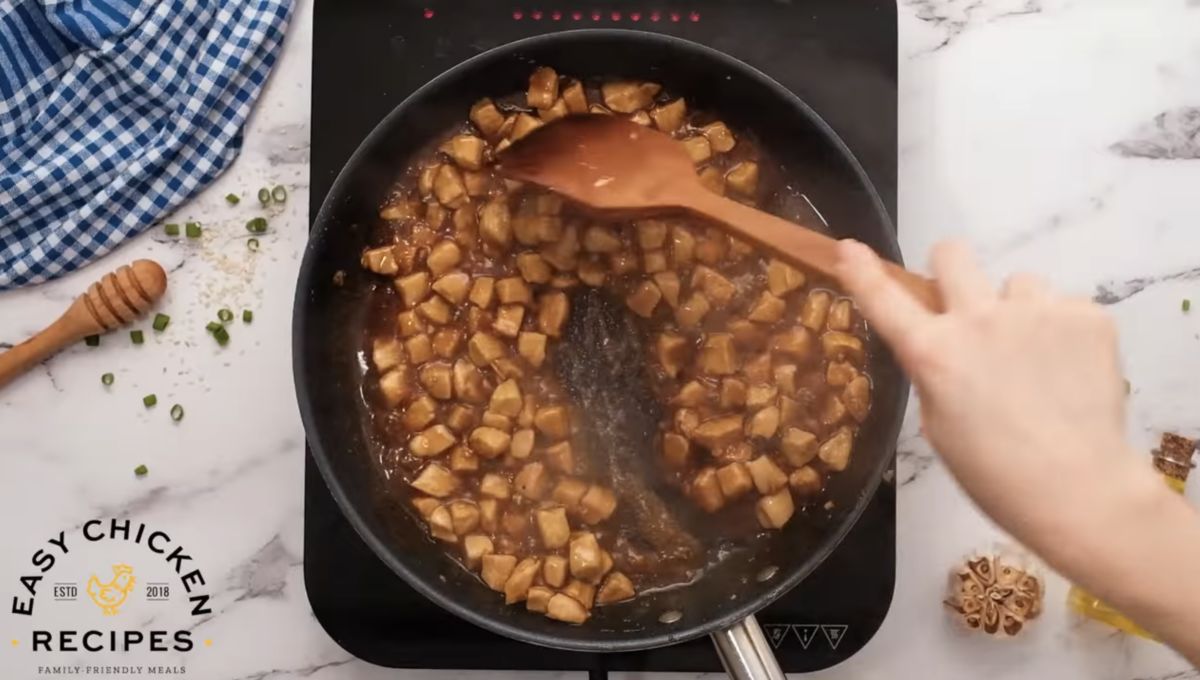 Teriyaki sauce is being cooked in a skillet with chicken. 