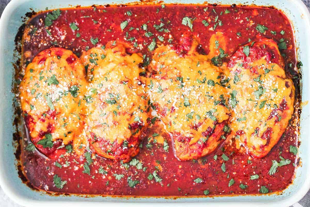 chicken breasts covered in salsa and cheese, in a baking dish