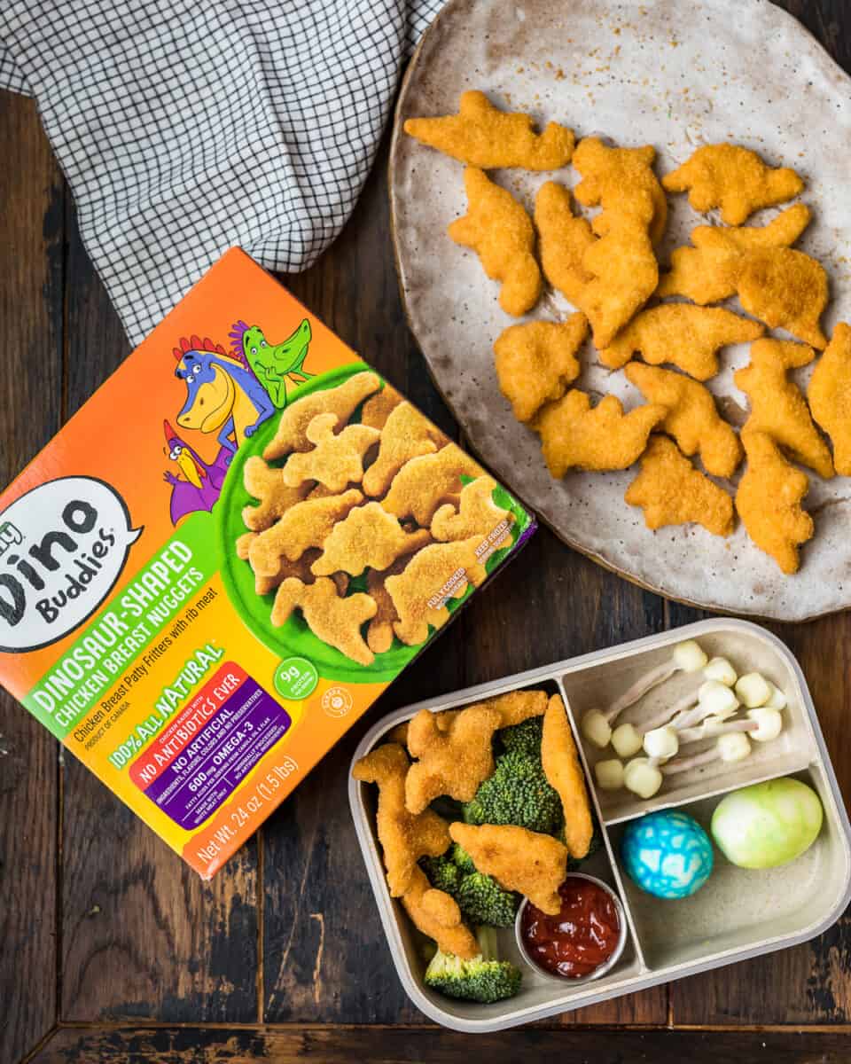 overhead shot of bento box made with dinosaur chicken nuggets and other dino food ideas