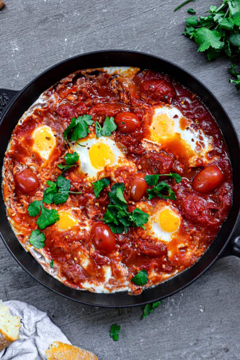top down shot of eggs and tomatoes in skillet