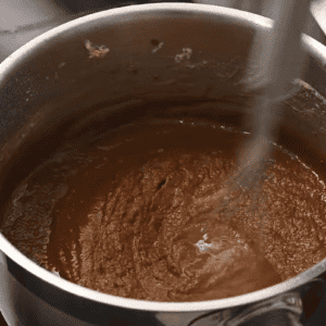 A roux is brown in a pot.
