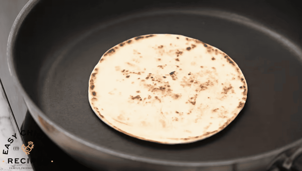 A tortilla is being warmed in a pan. 