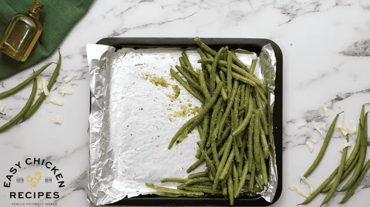 Green beans are placed on half of a baking sheet. 