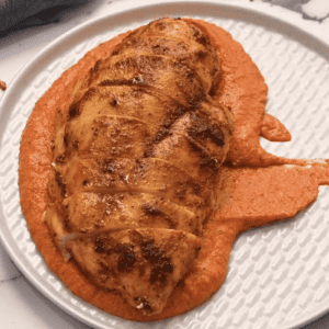 Romesco chicken breast served on a plate.