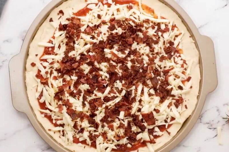 overhead view of a pizza topped with bacon crumbles.