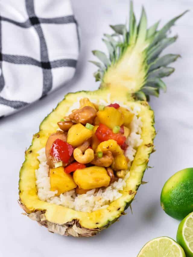 Half a pineapple with pineapple chicken on a bed of rice