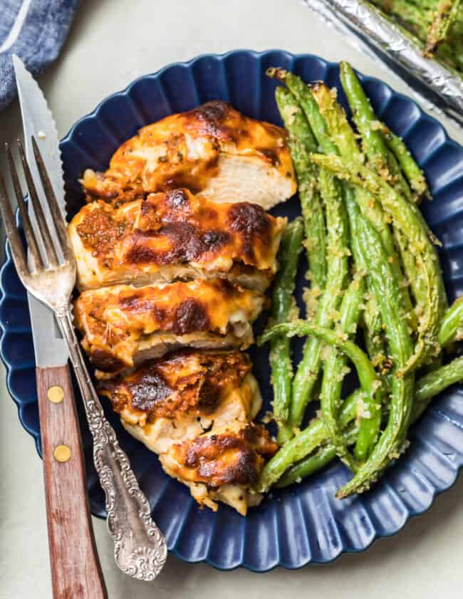 mozzarella chicken on a plate with green beans