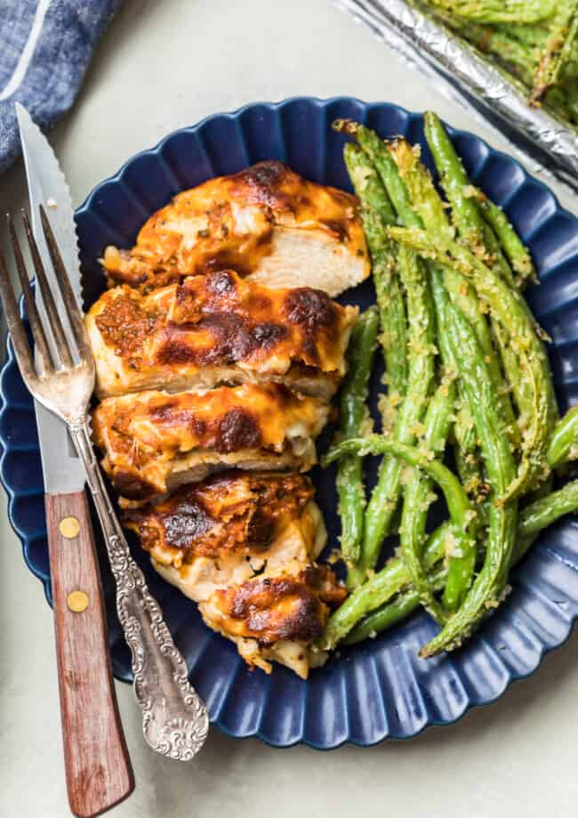 mozzarella chicken on a plate with green beans
