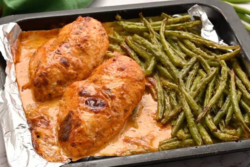 gooey baked sheet pan pesto mozzarella chicken and green beans.
