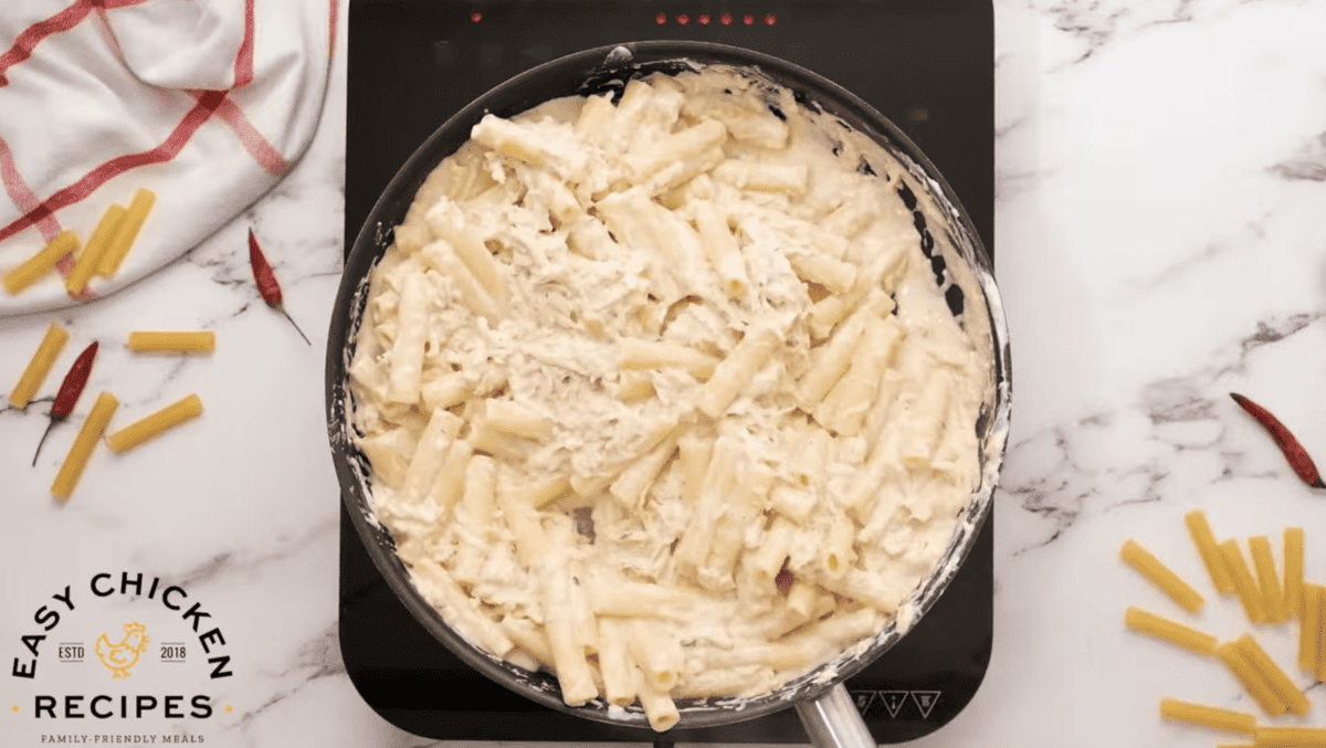 Pasta and chicken have been added to the skillet. 