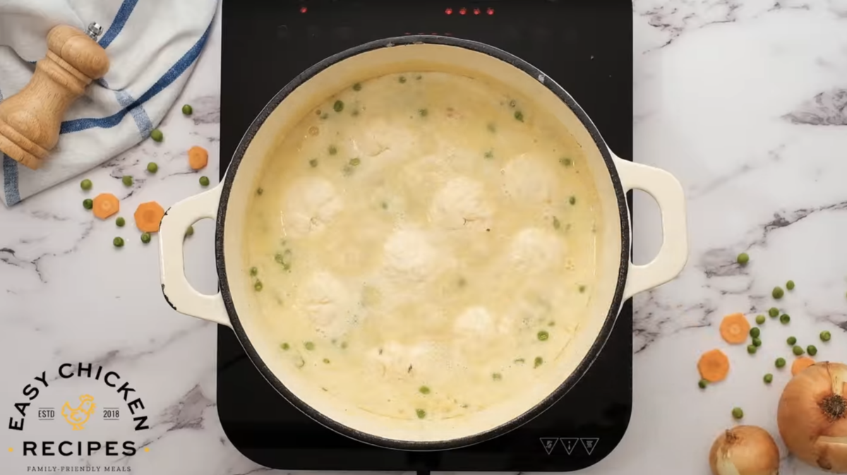 Dumplings are placed on top of the creamy chicken mixture. 