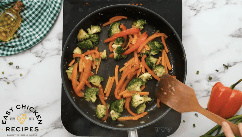 Veggies are being cooked in a pan.