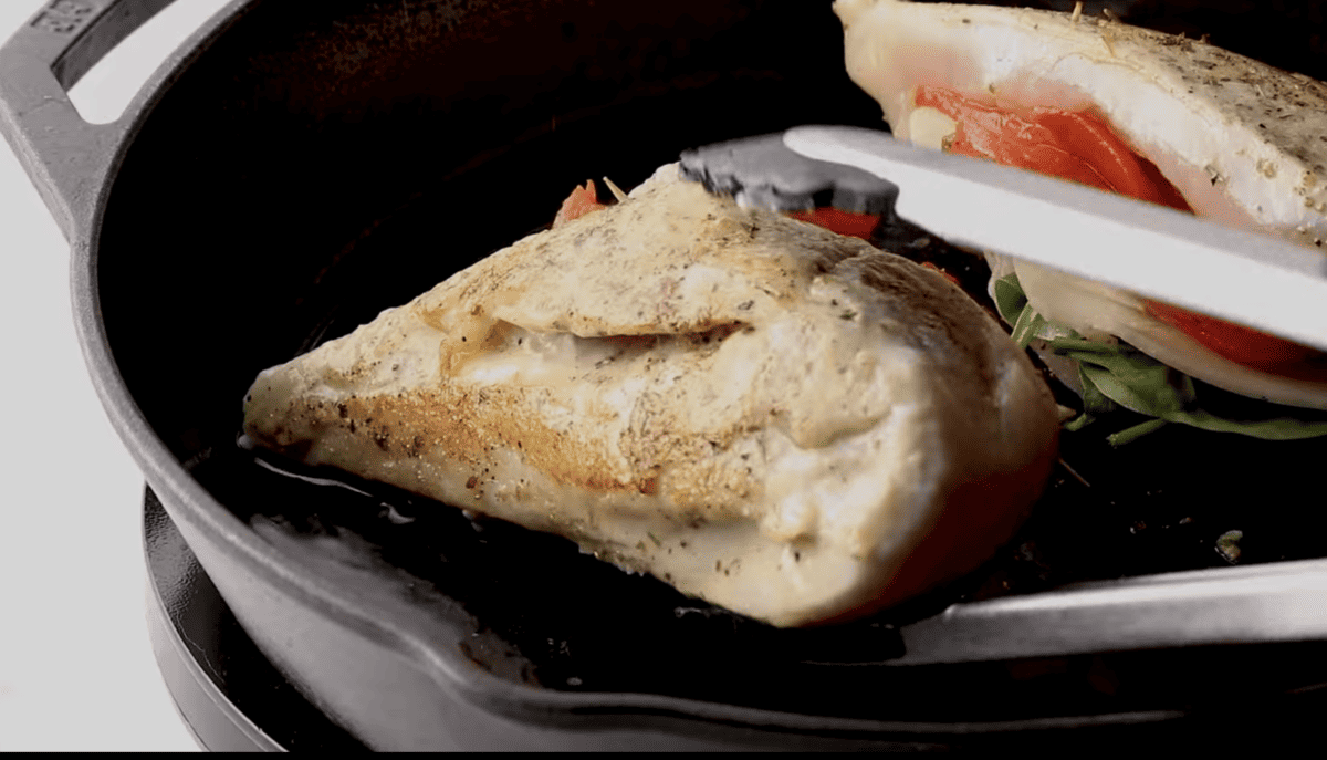 A delicious Stuffed Chicken Recipe featuring a frying pan with chicken and vegetables.