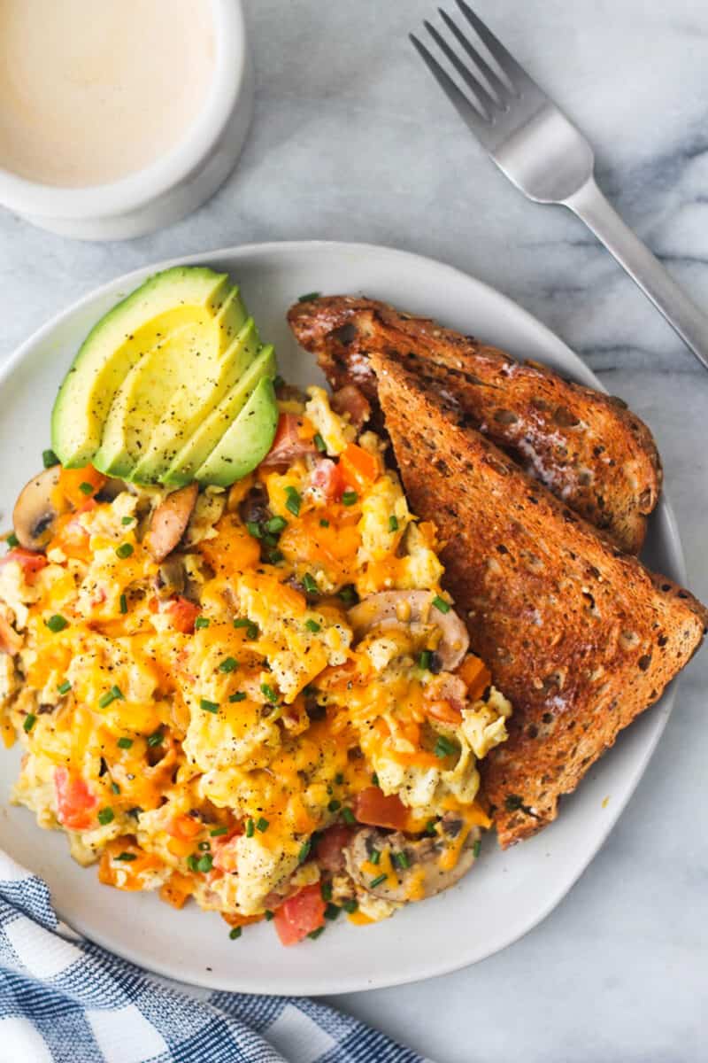 loaded scrambled eggs on plate with toast