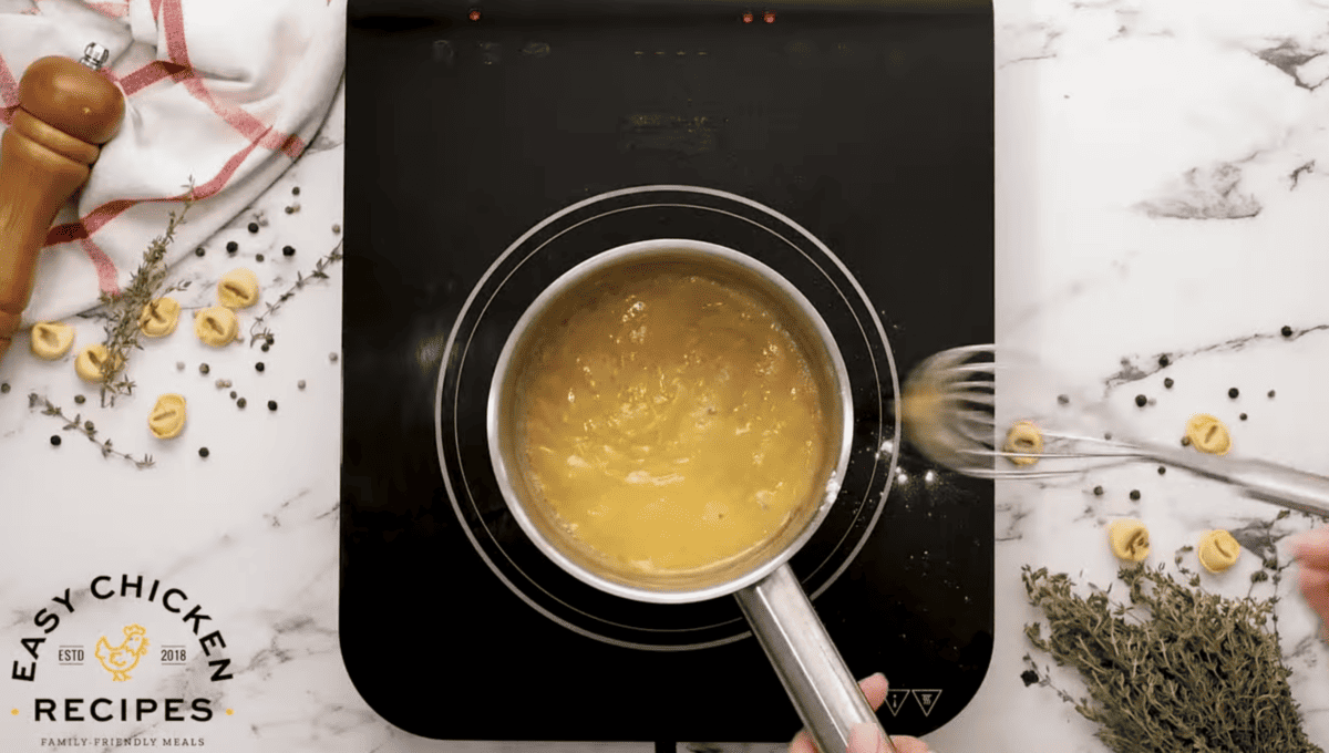 A roux is being whisked in a pot. 
