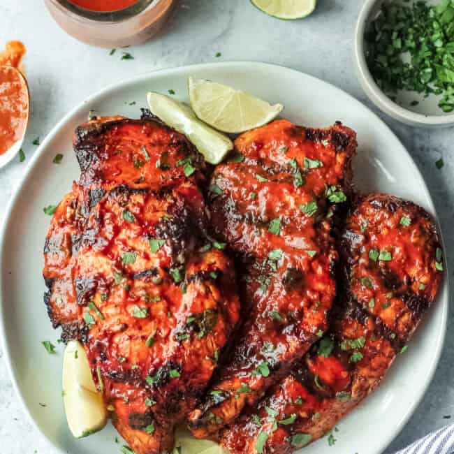 grilled chipotle chicken on plate with limes