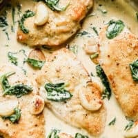 garlic chicken in skillet with cream sauce and spinach