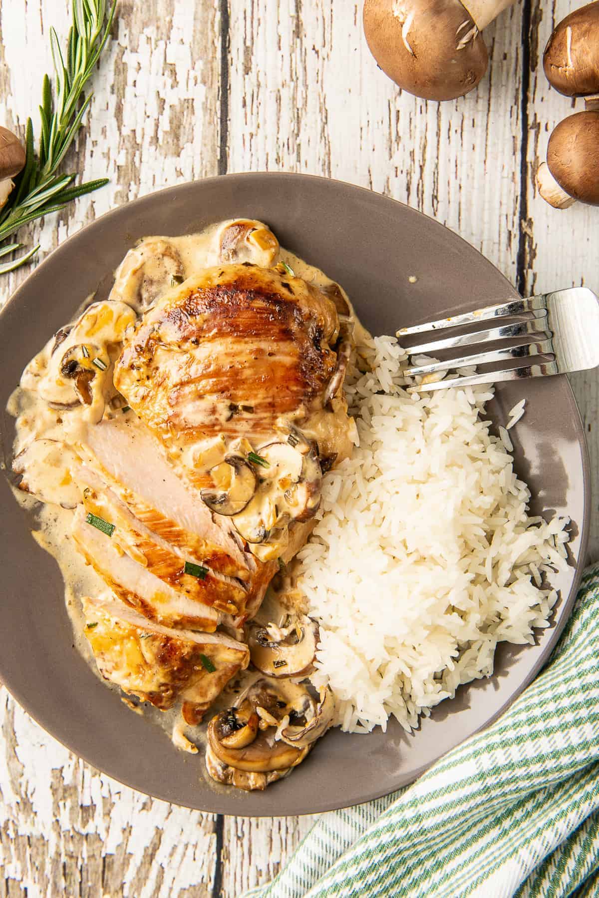 overhead image of sliced chicken in mushroom cream sauce on plate with rice