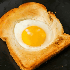 cooking an egg in the hole of a slice of toast.