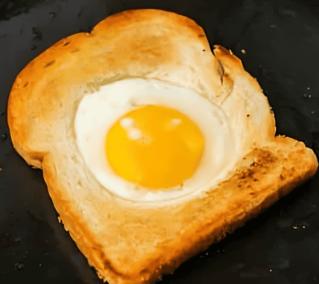 cooking an egg in the hole of a slice of toast.