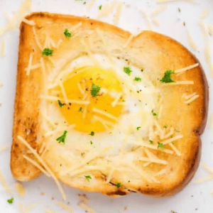 egg in a hole topped with parmesan and parsley.