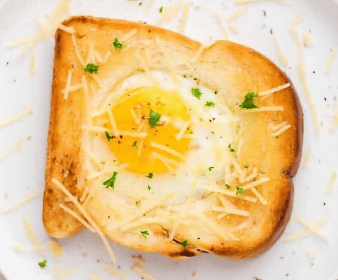 egg in a hole topped with parmesan and parsley.