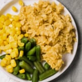 plate with chicken rice, green beans, and corn