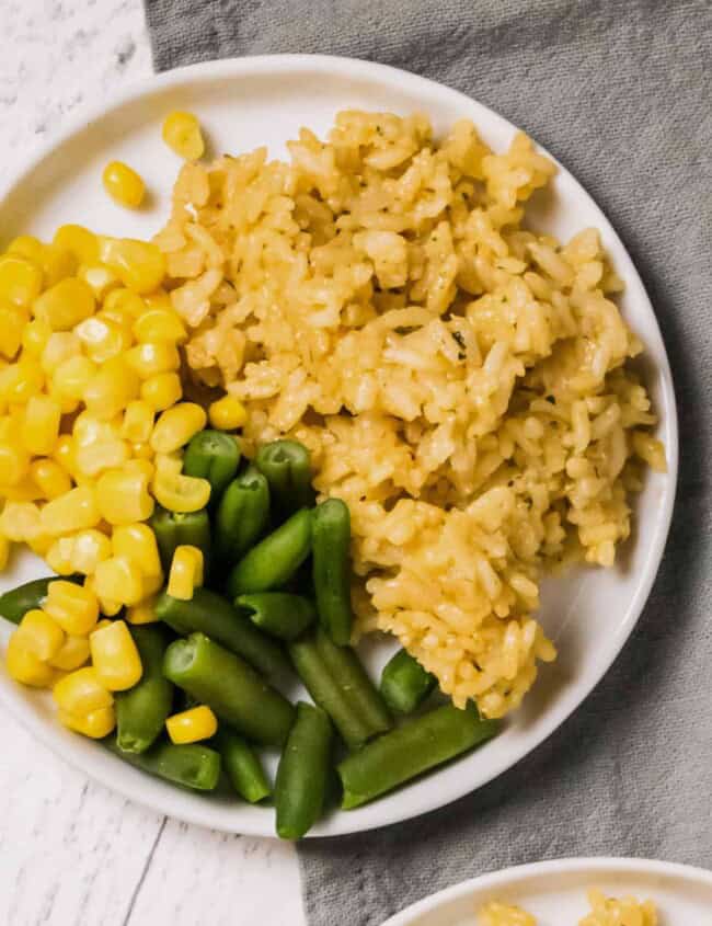 plate with chicken rice, green beans, and corn