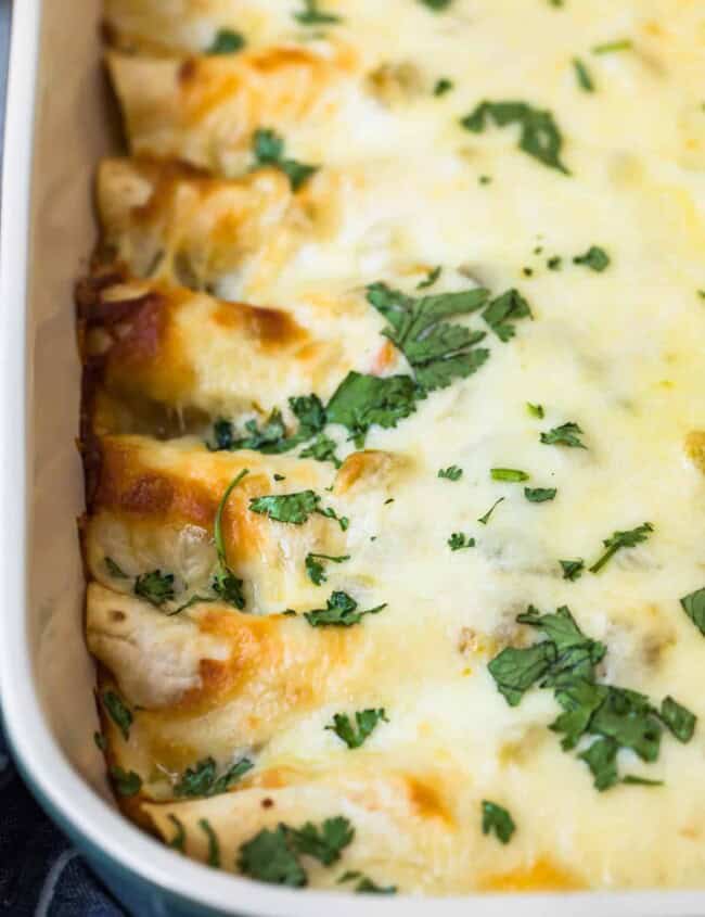 side shot of creamy white chicken enchiladas with cheese sauce