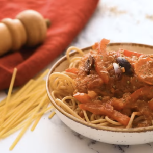 Chicken cacciatore with pasta is placed in a small bowl.