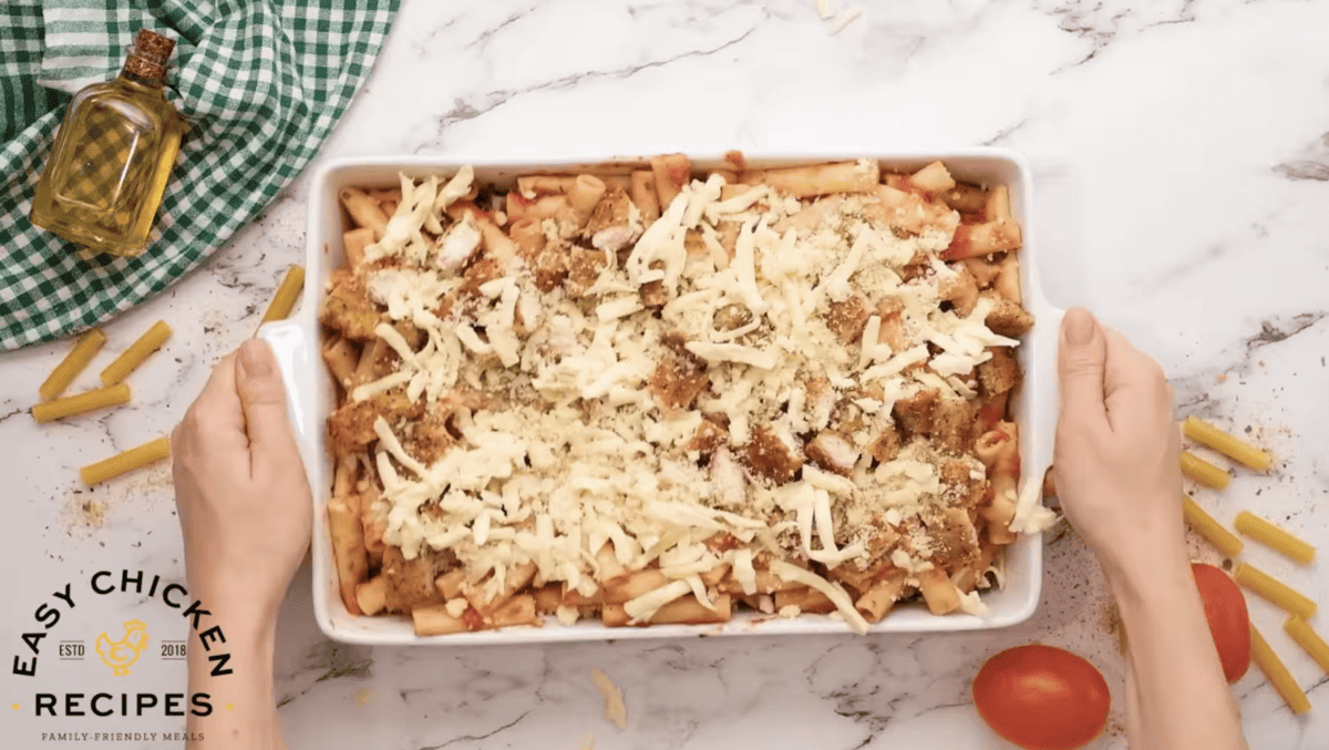 Unbaked chicken ziti is in a white baking dish. 