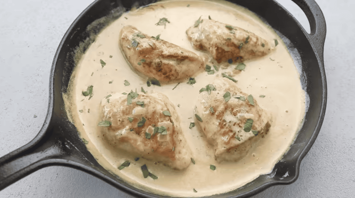 Chicken in cream sauce is garnished with parsley. 