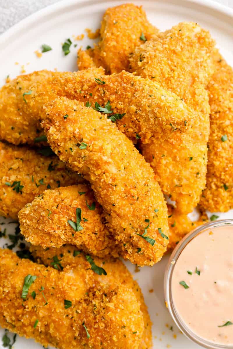 plate of stacked chicken tenders with sauce