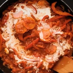 adding cream to cacciatore sauce in a pan.