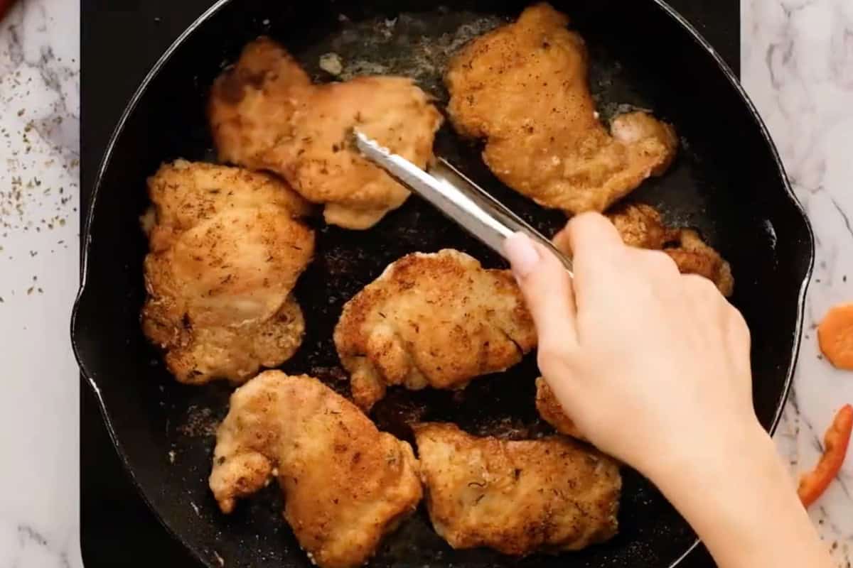 seared chicken thighs in a pan.
