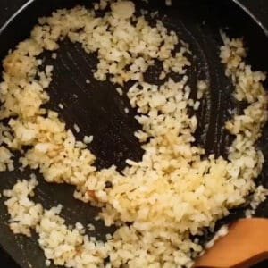 sautéeing diced onion in a pan.