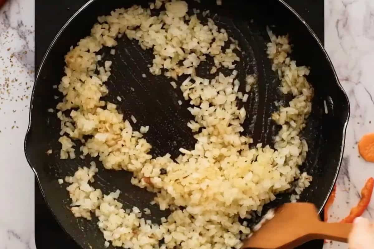 sautéeing diced onion in a pan.