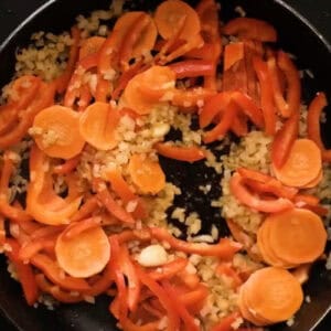 sautéeing diced onion and veggies in a pan.