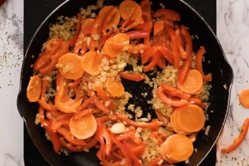 sautéeing diced onion and veggies in a pan.