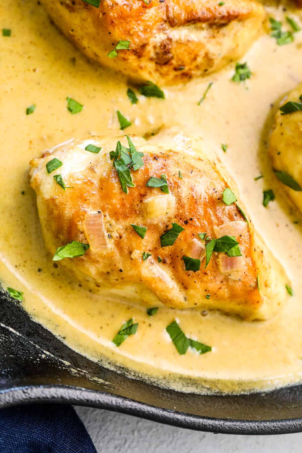 up close image of mustard chicken in cream sauce in skillet.